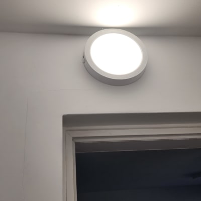 מנורת תקרה עגולה מוארת על קיר לבן