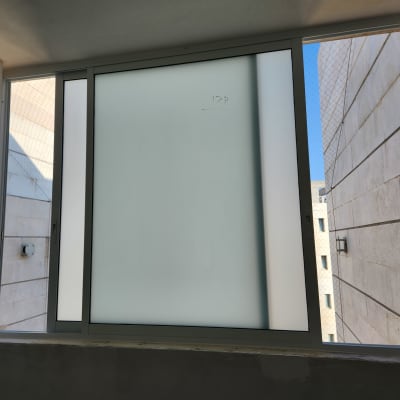 חלון אלומיניום עם זכוכית חלבית במסגרת לבנה