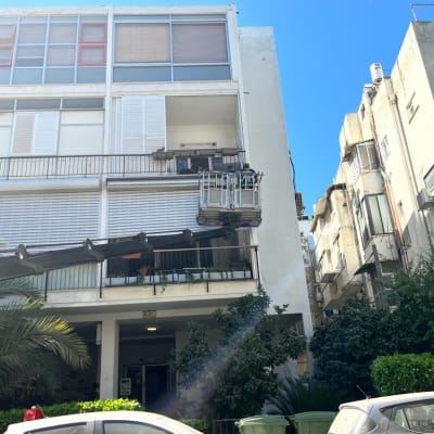 בניין עם תריסים לבנים פתוחים וסגורים