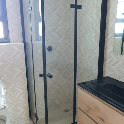 מקלחון זכוכית עם מסגרת שחורה וראש מקלחת מרובע