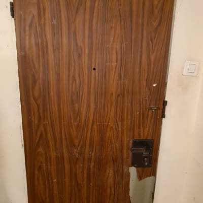 דלת עץ עם ציפוי מתקלף בחלק התחתון