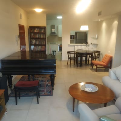 סלון עם פסנתר, שולחן עגול ומדפים