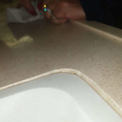 משטח שיש בהיר עם יד מנקה במטלית