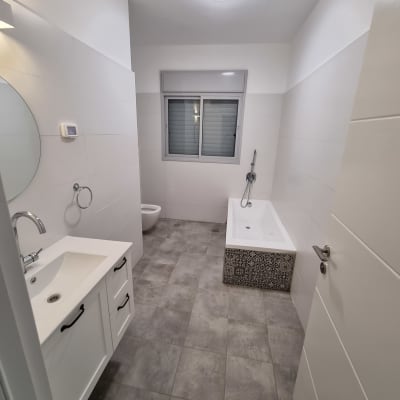 חדר אמבטיה נקי עם כיור ואמבטיה