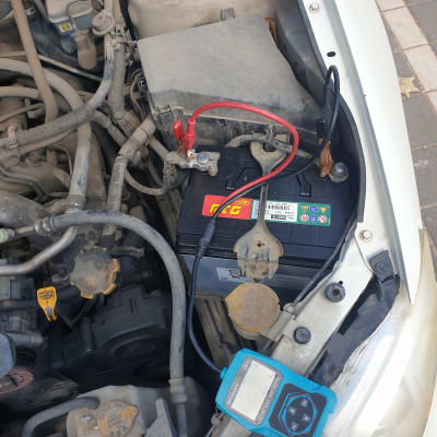 מצבר רכב עם כבלים מחוברים ומכשיר בדיקה