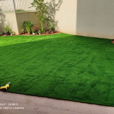 דשא סינתטי עם צמחים וכלי עבודה בגינה