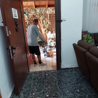 אדם מנקה עם שואב אבק במרפסת