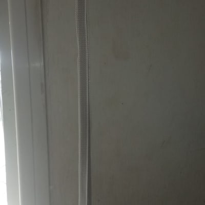 רצועת תריס לבנה על קיר אפור