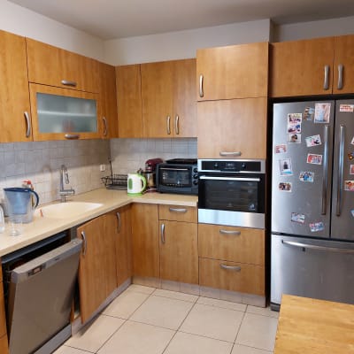 מטבח עם ארונות עץ, מקרר, תנור ומדיח כלים פתוח