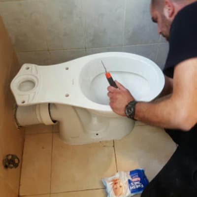 אדם מתקין אסלה עם מברג ביד