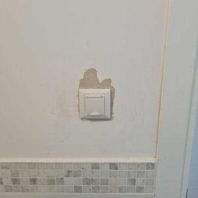 מתג חשמל מותקן על קיר עם תיקון טיח