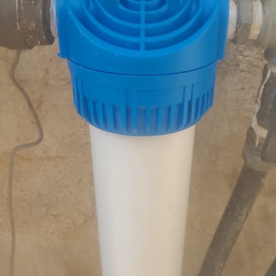 פילטר מים כחול ולבן מחובר לצינורות