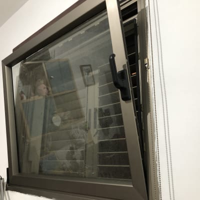 חלון עם תריסים פתוחים וידית שחורה