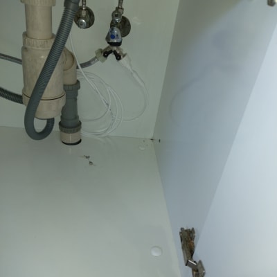 צנרת מתחת לכיור עם ברזים וצינורות