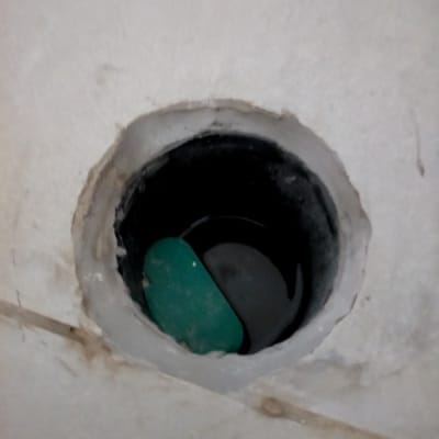 פתח ניקוז עם חפץ ירוק בפנים