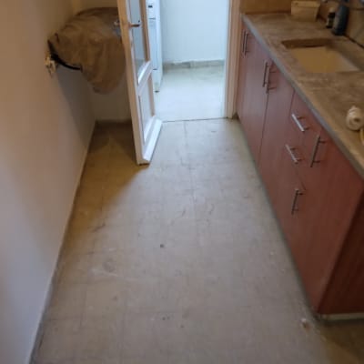 רצפה מלוכלכת במטבח עם כיור ומגבת