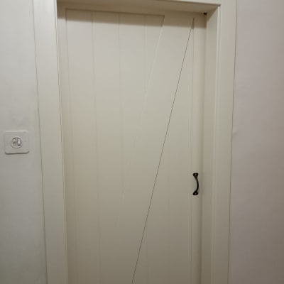 דלת עץ לבנה עם ידית מתכת שחורה