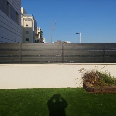 גדר אלומיניום שחורה על קיר לבן