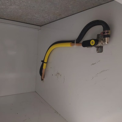 צינור גז צהוב עם שסתום מתכת על קיר לבן