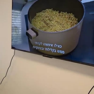 סיר עם אוכל על מסך טלוויזיה וחפצים על שולחן