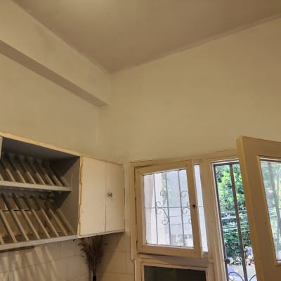 קיר צבוע בלבן עם ארון פתוח ליד חלון