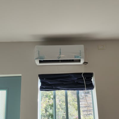 מזגן מותקן על קיר עם כיסוי פלסטיק שקוף
