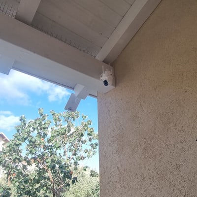 מצלמת אבטחה מותקנת על תקרת עץ ליד קיר חיצוני