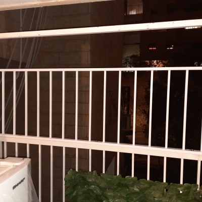 מעקה מתכת לבן במרפסת בלילה