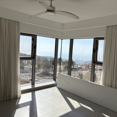 חדר עם חלונות גדולים ווילונות לבנים