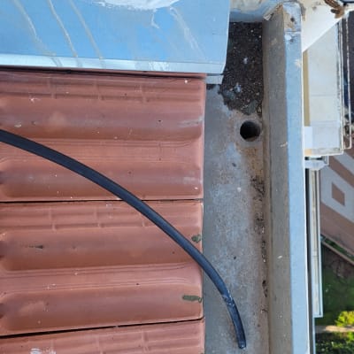 רעפים אדומים על גג עם כבל שחור