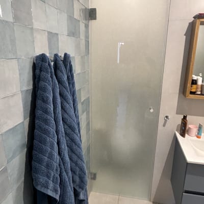 דלת זכוכית חלבית במקלחת עם ידית מתכת