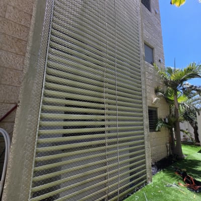 רשת מתוחה על קיר בניין עם כלי עבודה על הדשא