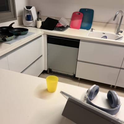 מטבח עם כלים על השיש, כולל קרש חיתוך