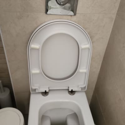 אסלה עם מכסה פתוח בחדר אמבטיה