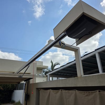 שער חשמלי מותקן בחצר עם שמיים כחולים ברקע