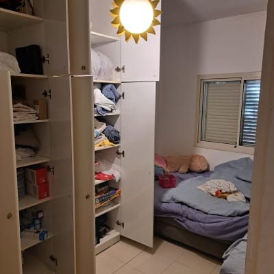 ארון בגדים מסודר בחדר שינה עם מיטה