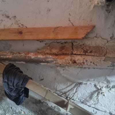 צינור חלוד עם סדקים ותמיכה מעץ