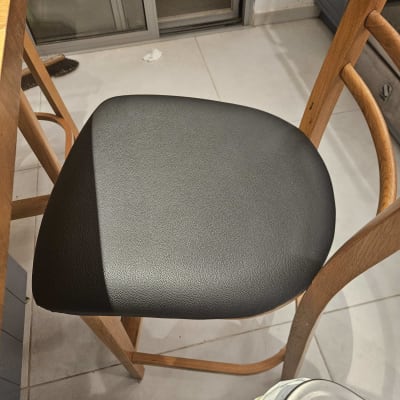 כיסא עם ריפוד עור שחור ליד שולחן עץ