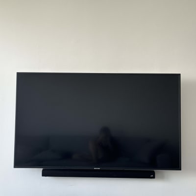 טלוויזיה תלויה על הקיר עם סאונד בר מתחת