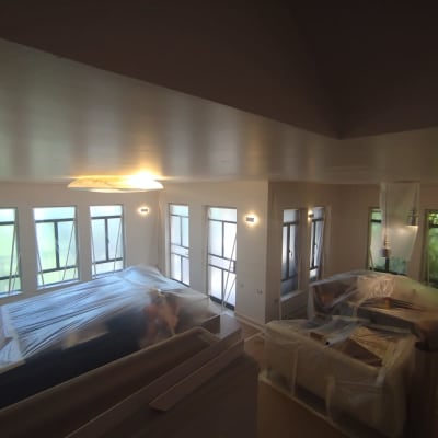 חדר עם רהיטים מכוסים בניילון לקראת צביעה