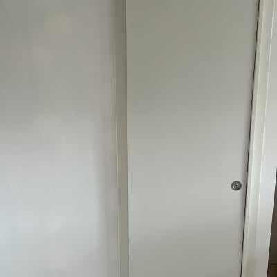 דלת הזזה לבנה על רקע קיר בהיר