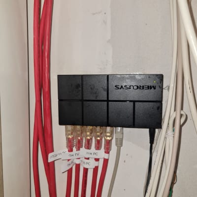 כבלים אדומים מחוברים למפצל רשת על קיר