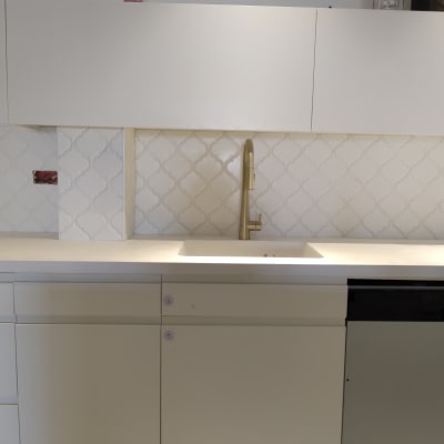 כיור מטבח עם ברז זהב ואריחים לבנים