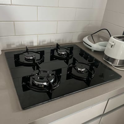 כיריים גז שחורות עם ארבעה מבערים על משטח מטבח