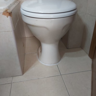 אסלה לבנה עם מכסה סגור בחדר אמבטיה