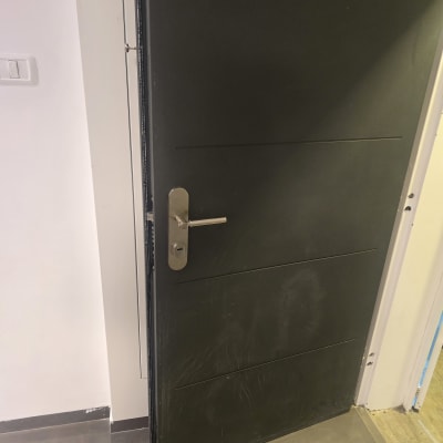 דלת שחורה פתוחה עם ידית מתכת