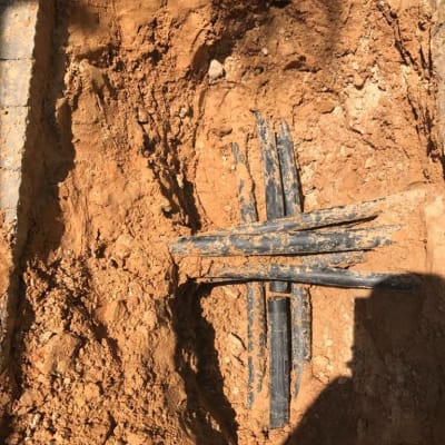 צינורות שחורים מונחים בתוך חפירה באדמה