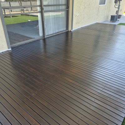 דק עץ חום מותקן בחצר ליד בית