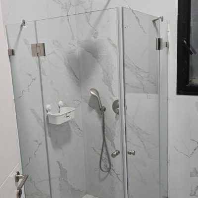 מקלחון זכוכית עם ראש מקלחת וכיור קטן