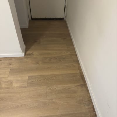 רצפת עץ ליד קיר לבן ודלת סגורה